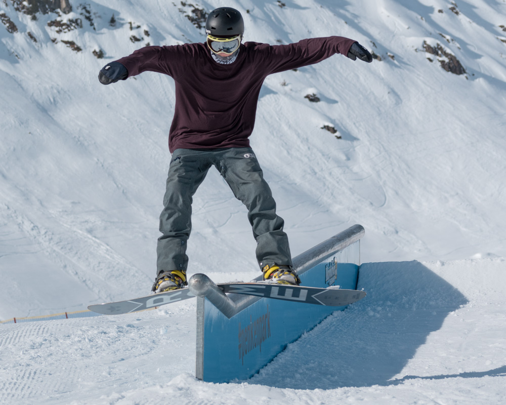 Snowboarder boardsliding as rail.